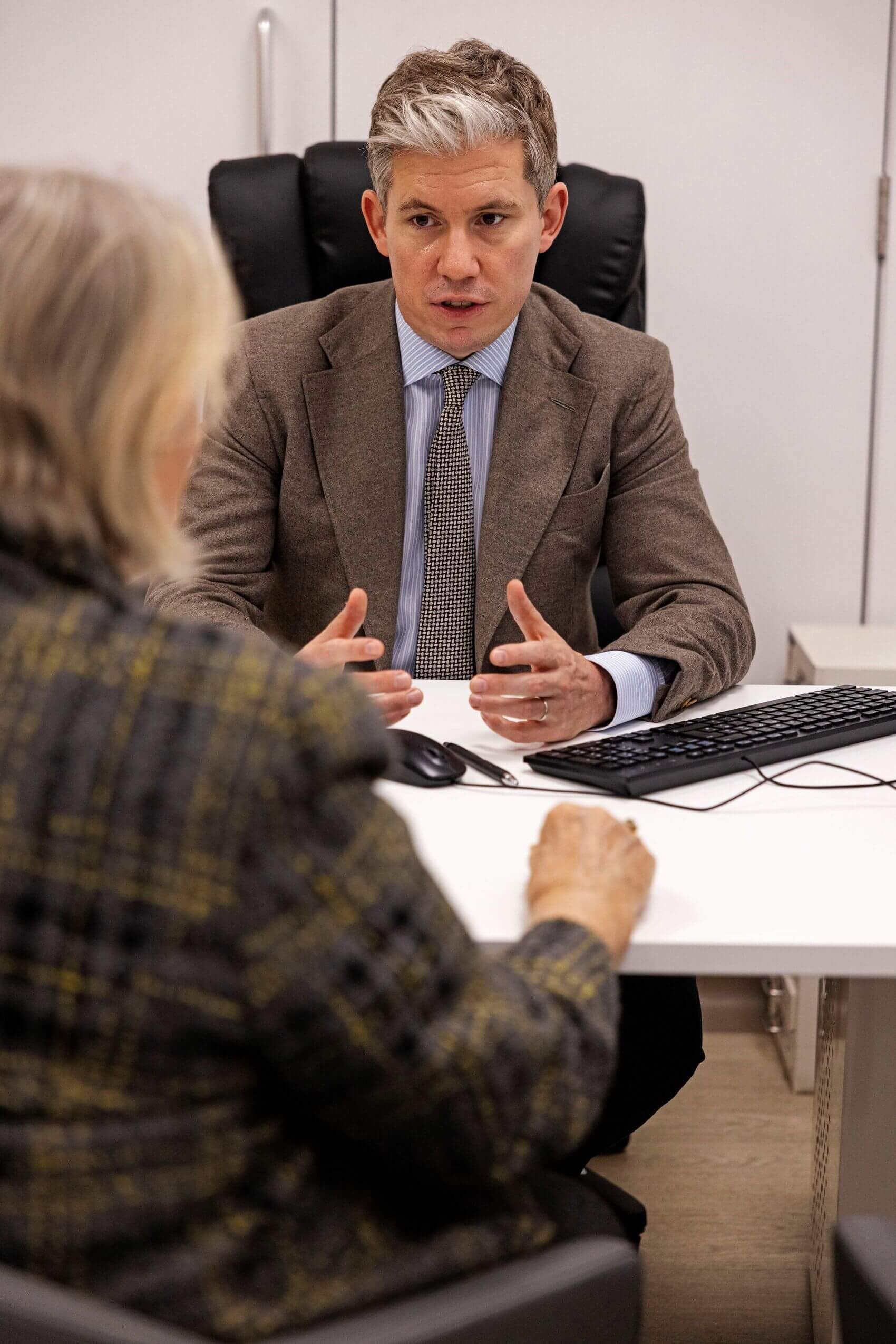 Dr James Wilson describing cancer blood test results to a patient. Cancer blood tests for ctDNA can be used to detect recurrence, direct treatment decisions and screen for cancer