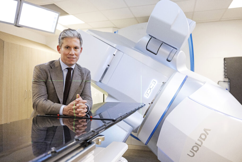 Dr James Wilson, London Cancer Specialist, with a radiotherapy machine, talks about treatment for stage 4 cancer
